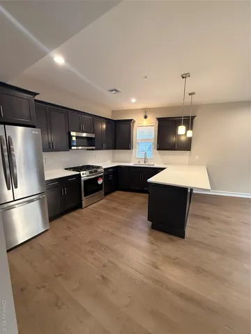 a large kitchen with kitchen island a sink stainless steel appliances and cabinets