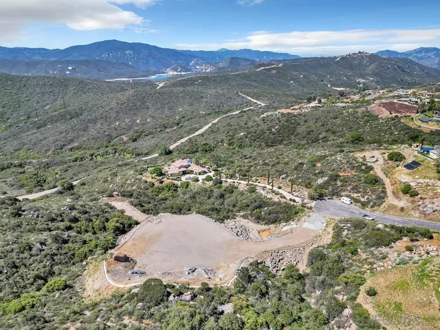 an aerial view of residential house with space and mountain view in back
