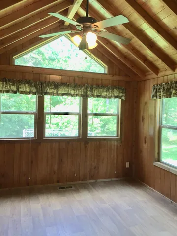 a view of an empty room with a window and a ceiling fan