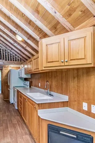a kitchen with stainless steel appliances granite countertop a sink a stove and a wooden floors