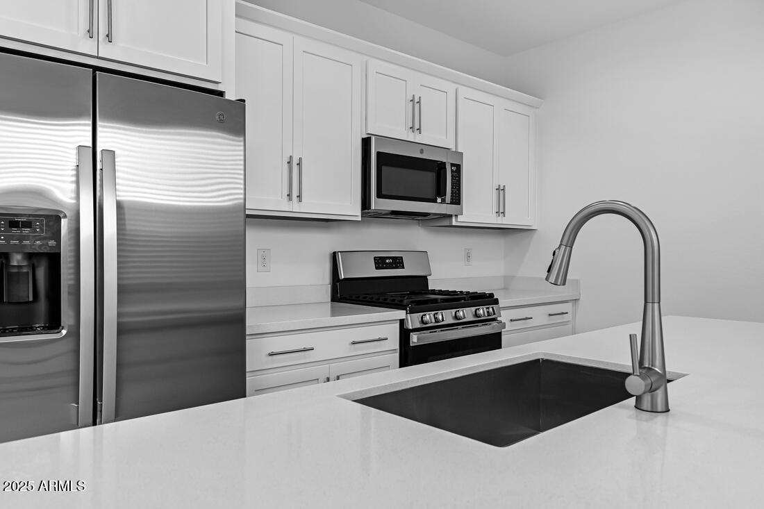9964 West Piccadilly Road Avondale, AZ 85392 - Photo 16 of 52 a kitchen with a refrigerator stove and cabinets
