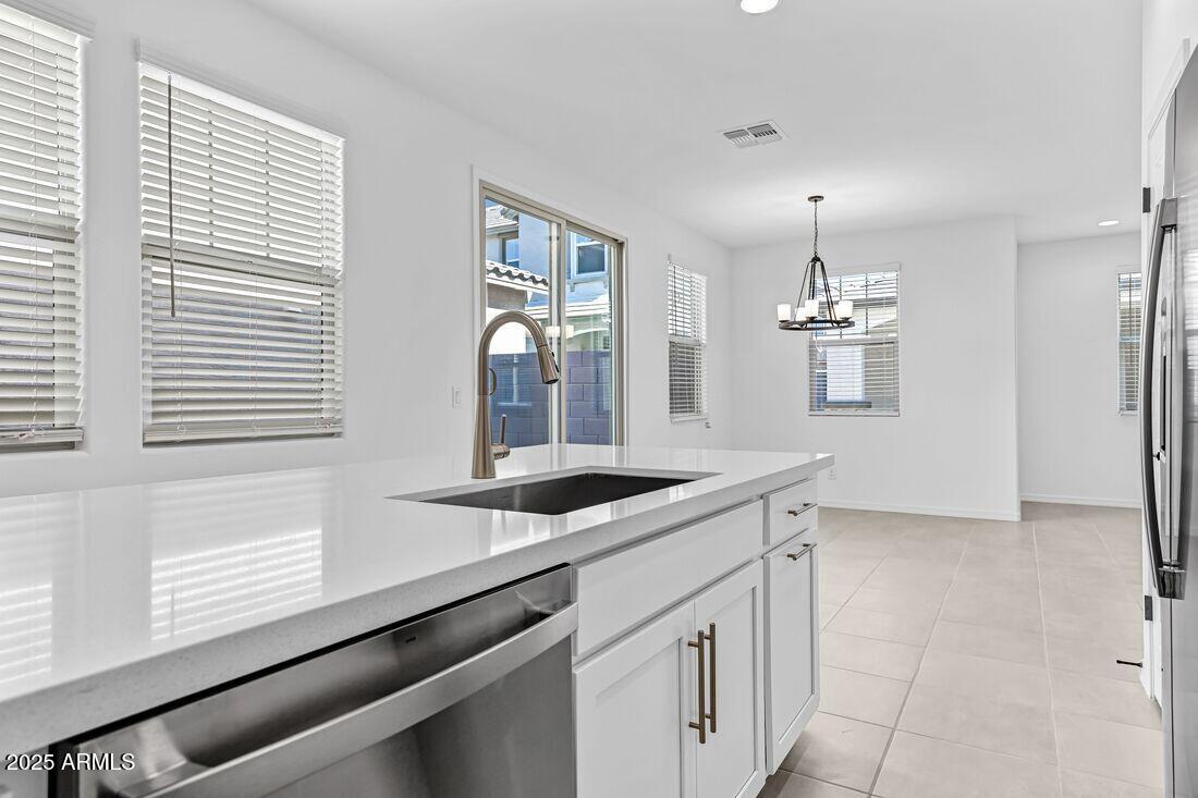 9964 West Piccadilly Road Avondale, AZ 85392 - Photo 18 of 52 a kitchen with granite countertop a sink and a white wooden cabinets