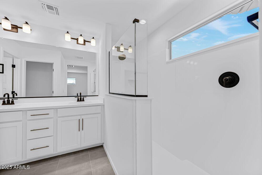 9964 West Piccadilly Road Avondale, AZ 85392 - Photo 25 of 52 a bathroom with a granite countertop sink two mirror and a shower