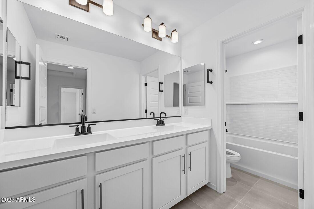 9964 West Piccadilly Road Avondale, AZ 85392 - Photo 28 of 52 a bathroom with a sink a toilet and a large mirror