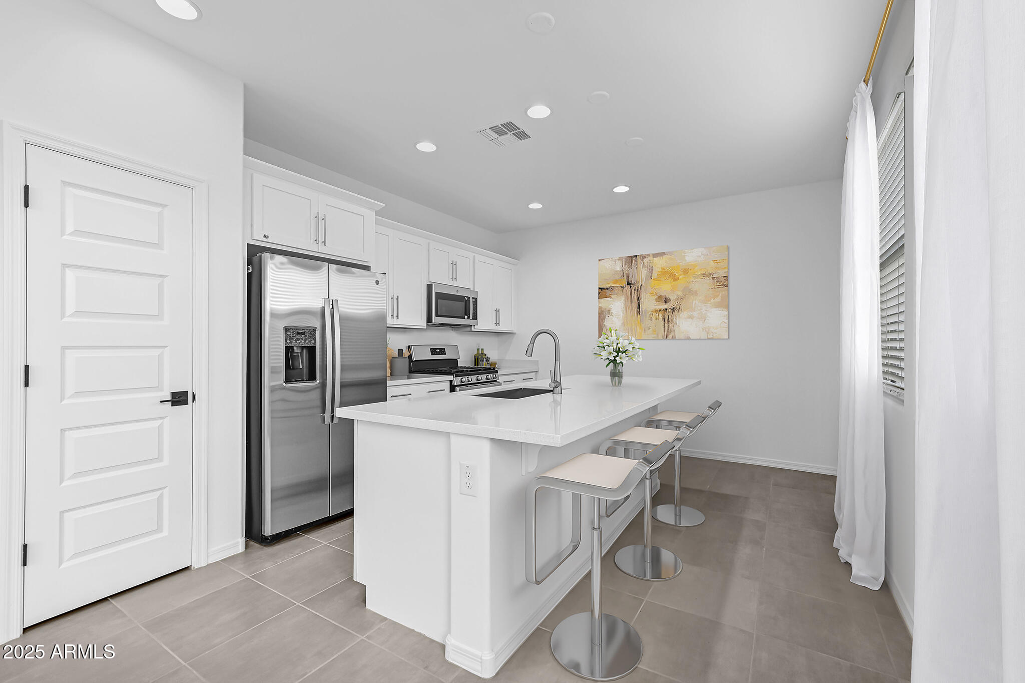 9964 West Piccadilly Road Avondale, AZ 85392 - Photo 6 of 52 a kitchen with stainless steel appliances a refrigerator and a stove top oven