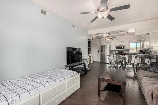 a bedroom with furniture and a view of kitchen