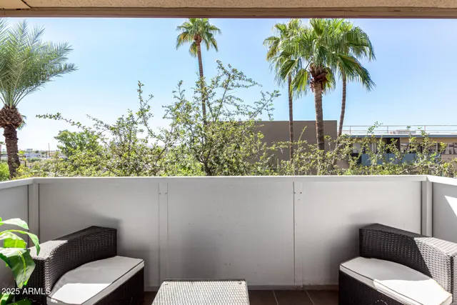 a view of a balcony with chair and potted plants