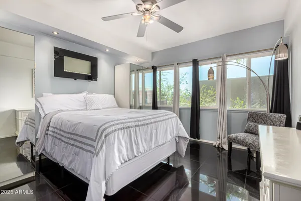 a bedroom with a bed and a large window