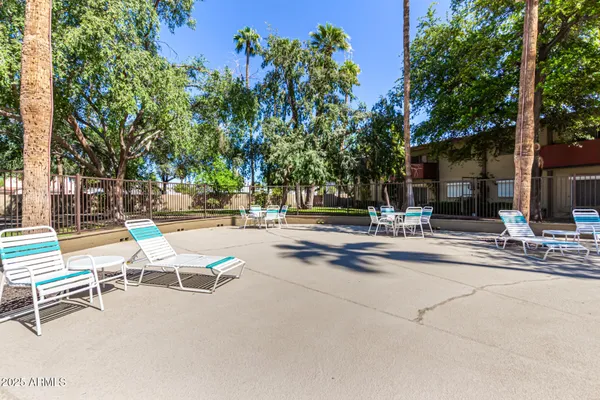 a view of a patio with a bench and tables