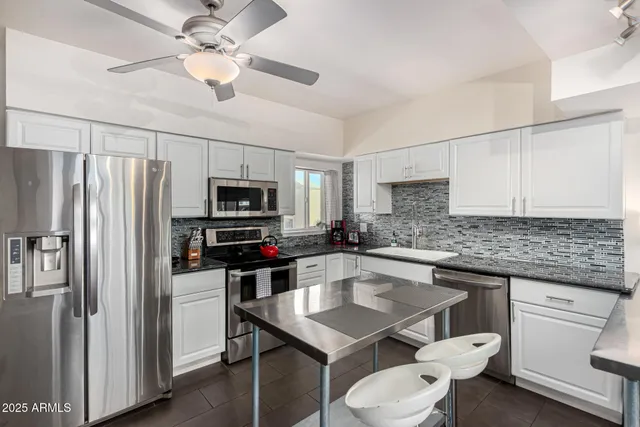 a kitchen with white cabinets stainless steel appliances and a counter space