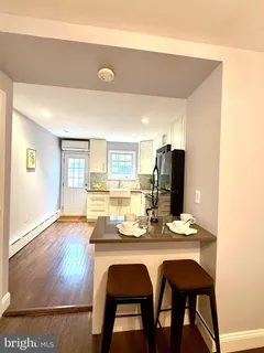 a dining room with wooden floor and refrigerator