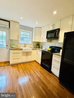 a kitchen with wooden floors and black appliances