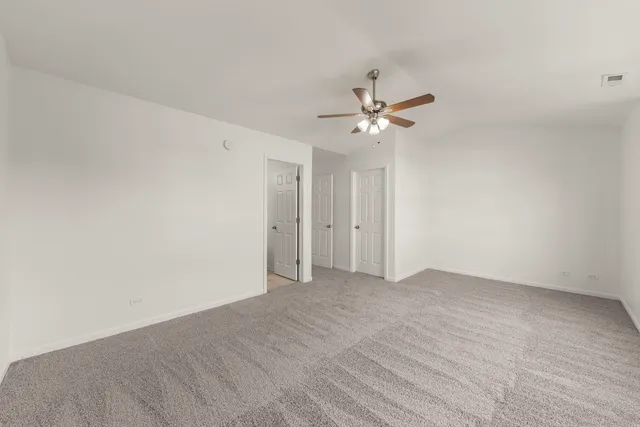 a view of an empty room with a ceiling fan