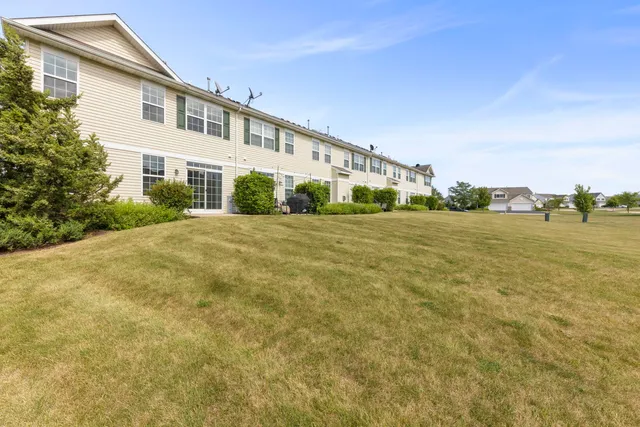 a view of a big house with a big yard and large trees