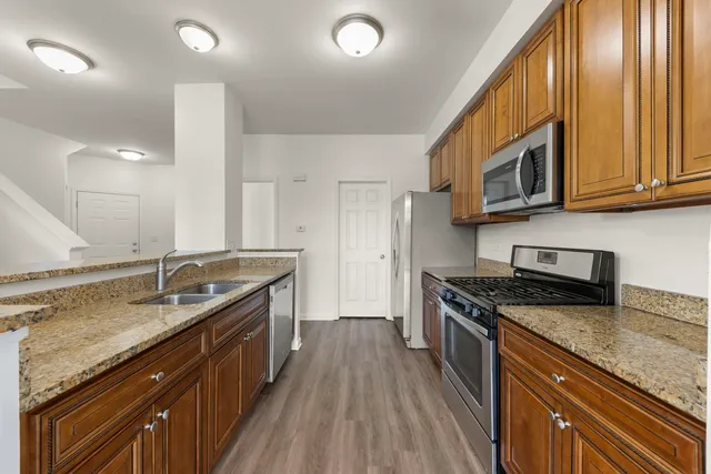 a kitchen with stainless steel appliances granite countertop a sink stove and cabinets