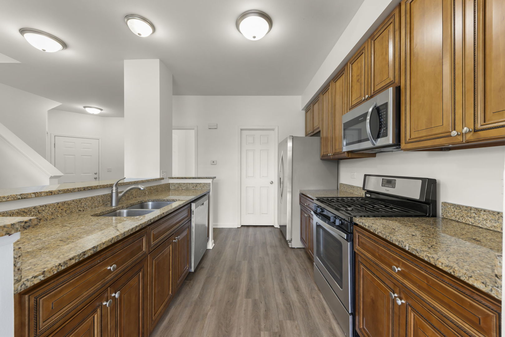 1034 Turin Drive Hampshire, IL 60140 - Photo 5 of 23 a kitchen with stainless steel appliances granite countertop a sink stove and cabinets