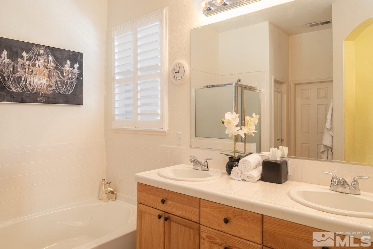 1725 Colavita Way Reno, NV 89521 - Photo 13 of 22 a bathroom with a tub sink and mirror
