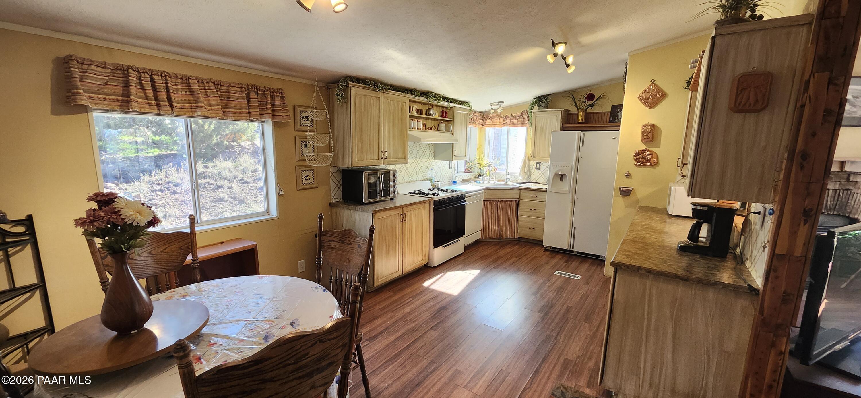 2373 Roberts Road Ash Fork, AZ 86320 - Photo 7 of 41 a kitchen with stainless steel appliances a refrigerator a sink dishwasher a stove and white countertops with wooden floor