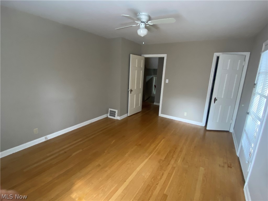 4218 Silsby Road University Heights, OH 44118 - Photo 13 of 27 Hardwood flooring, painted walls, ceiling fan with light fixture, white trim, and white doors