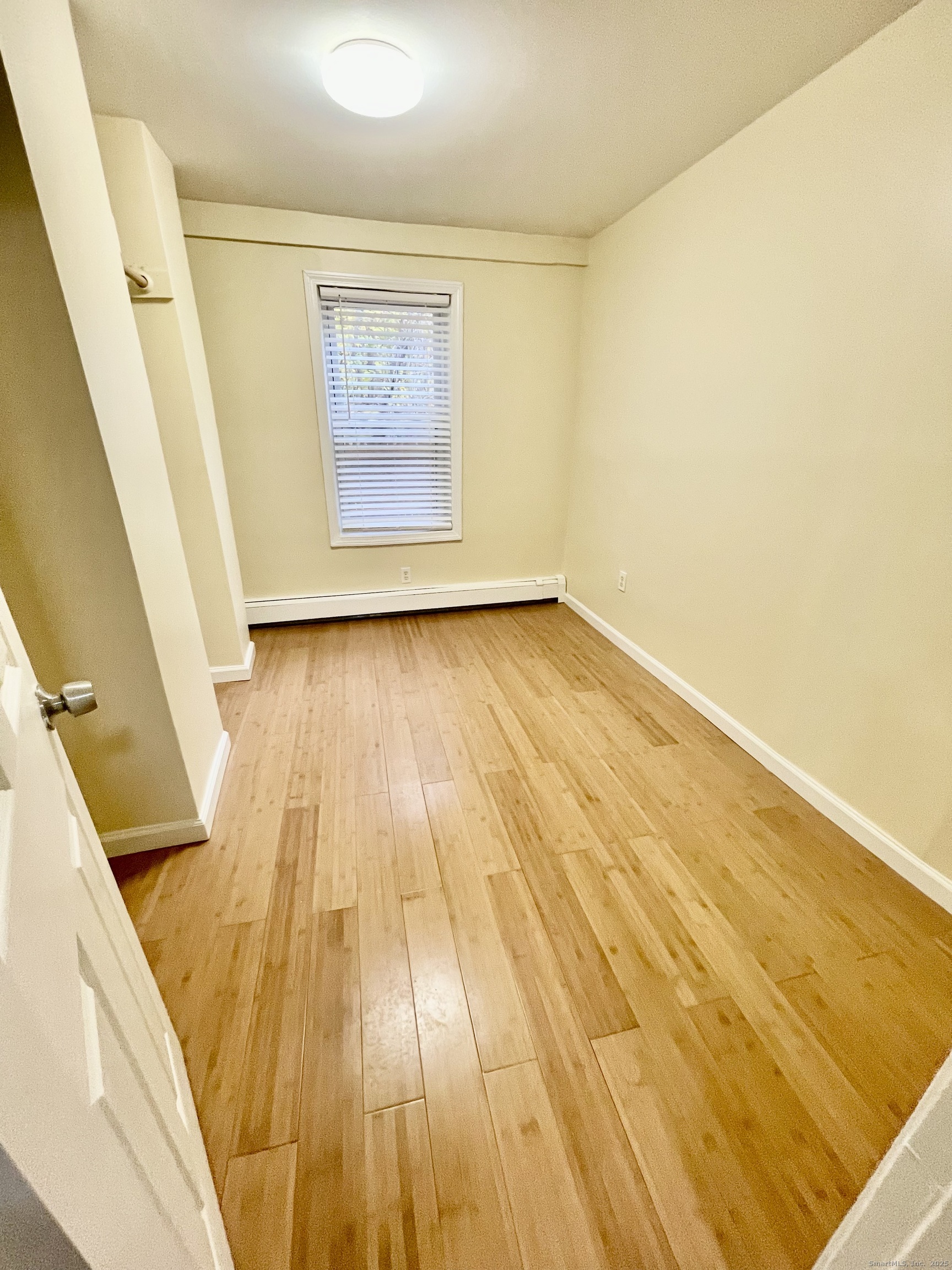 92 West Main Street, Unit 4 Vernon, CT 06066 - Photo 6 of 10 a view of an empty room with wooden floor and a window