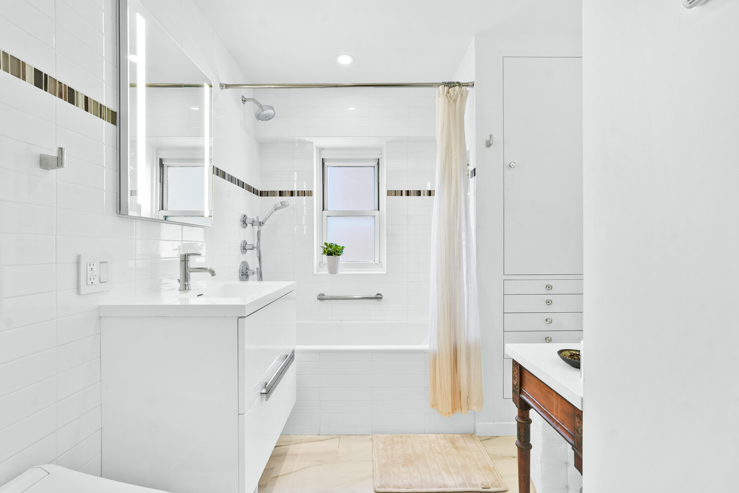 268 East Broadway, Unit A1706 Manhattan, NY 10002 - Photo 14 of 39 a bathroom with a bathtub sink and mirror