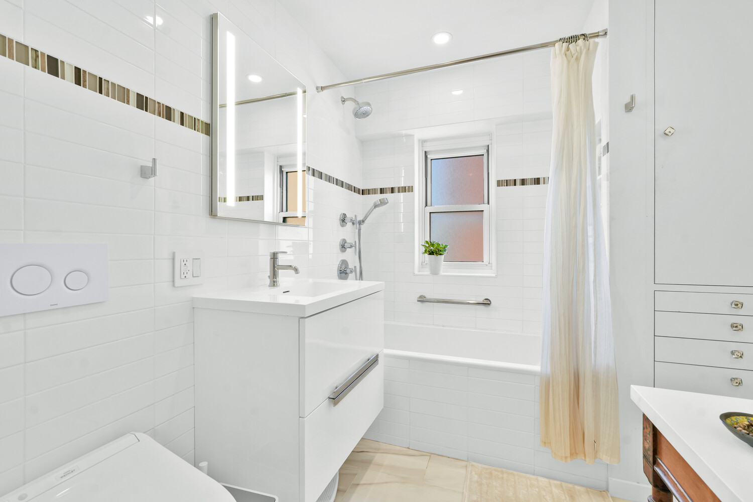 268 East Broadway, Unit A1706 Manhattan, NY 10002 - Photo 3 of 39 a bathroom with a sink a mirror and a bathtub