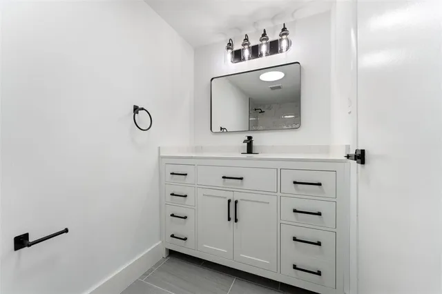 a bathroom with a sink vanity and mirror