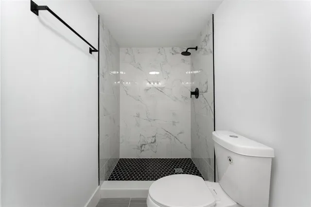 a bathroom with a toilet and a shower