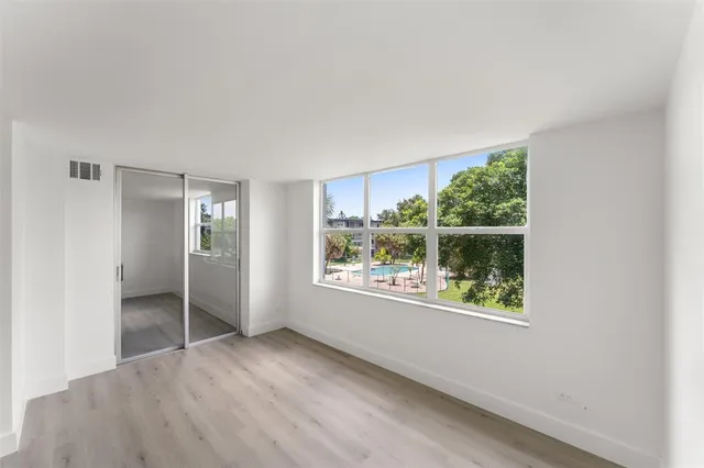 an empty room with windows and closet