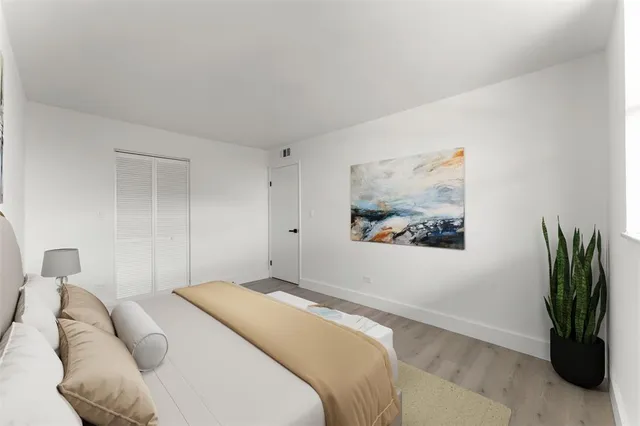 a bedroom with a bed and a painting on the wall