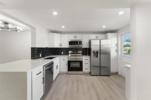 a kitchen with granite countertop a refrigerator stove and oven