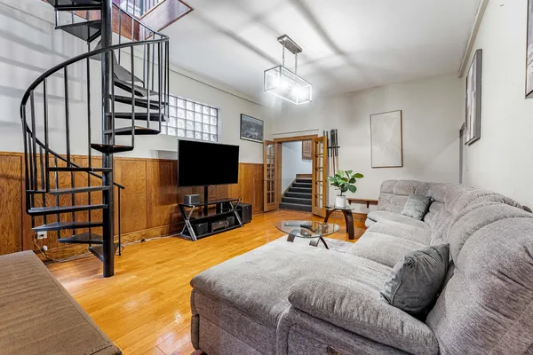 a bedroom with a bed a flat screen tv and a chandelier