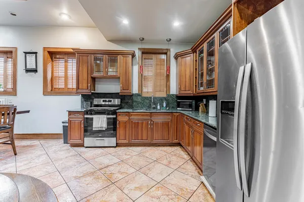 a kitchen with stainless steel appliances granite countertop a refrigerator and a stove