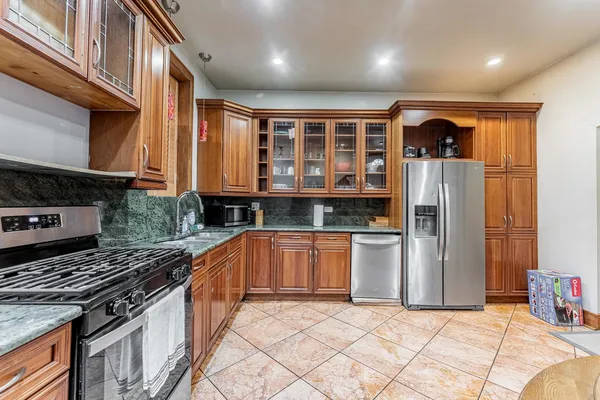 a kitchen with stainless steel appliances granite countertop a stove a sink and a refrigerator