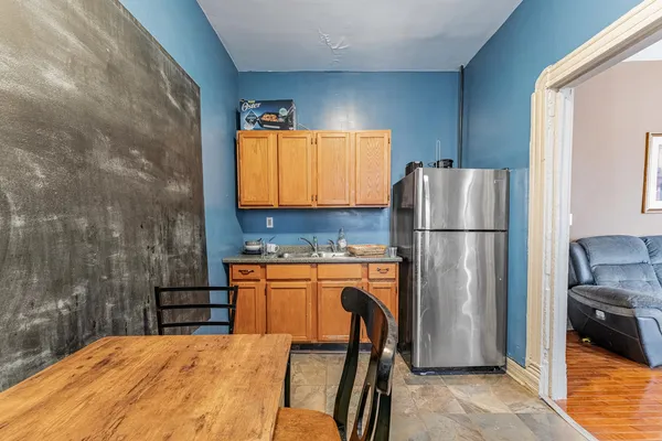 a kitchen with stainless steel appliances granite countertop a refrigerator a stove a sink a dining table and chairs