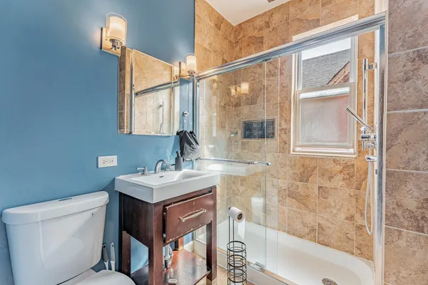 a bathroom with a sink toilet vanity and shower