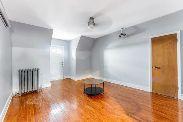 a room with wooden floor and chandelier