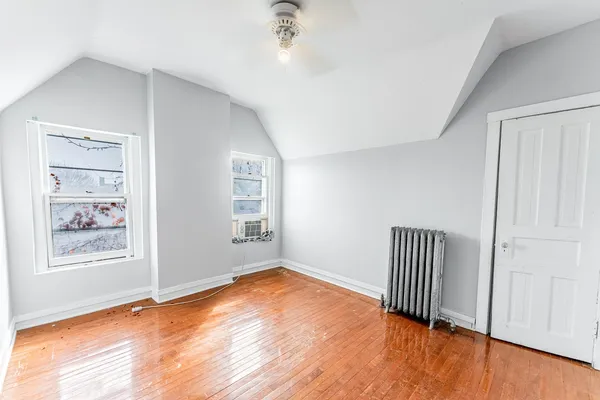 a view of empty room with wooden floor