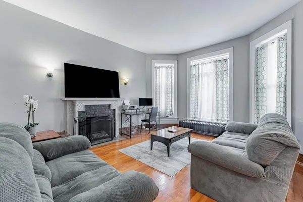 a living room with furniture a fireplace and a flat screen tv