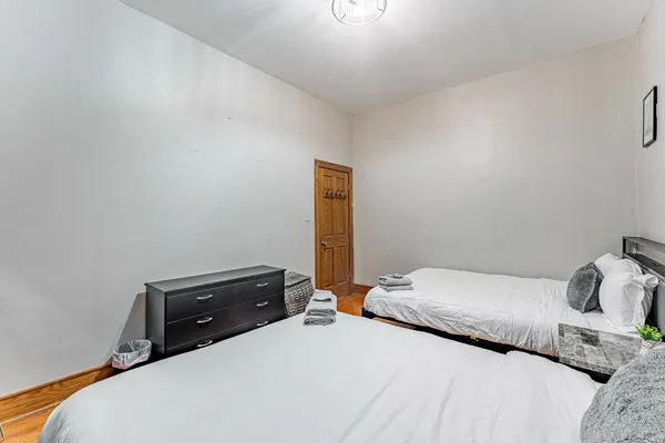 a bedroom with a bed and a lamp on the dresser