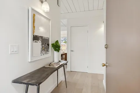 a living room with a table and a potted plant