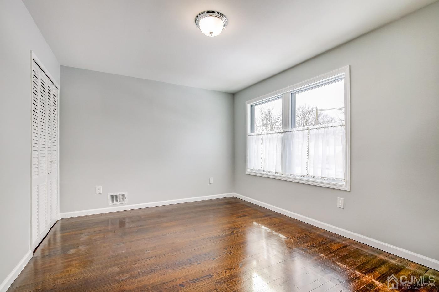 59 Stony Road Edison, NJ 08817 - Photo 20 of 27 an empty room with wooden floor and windows