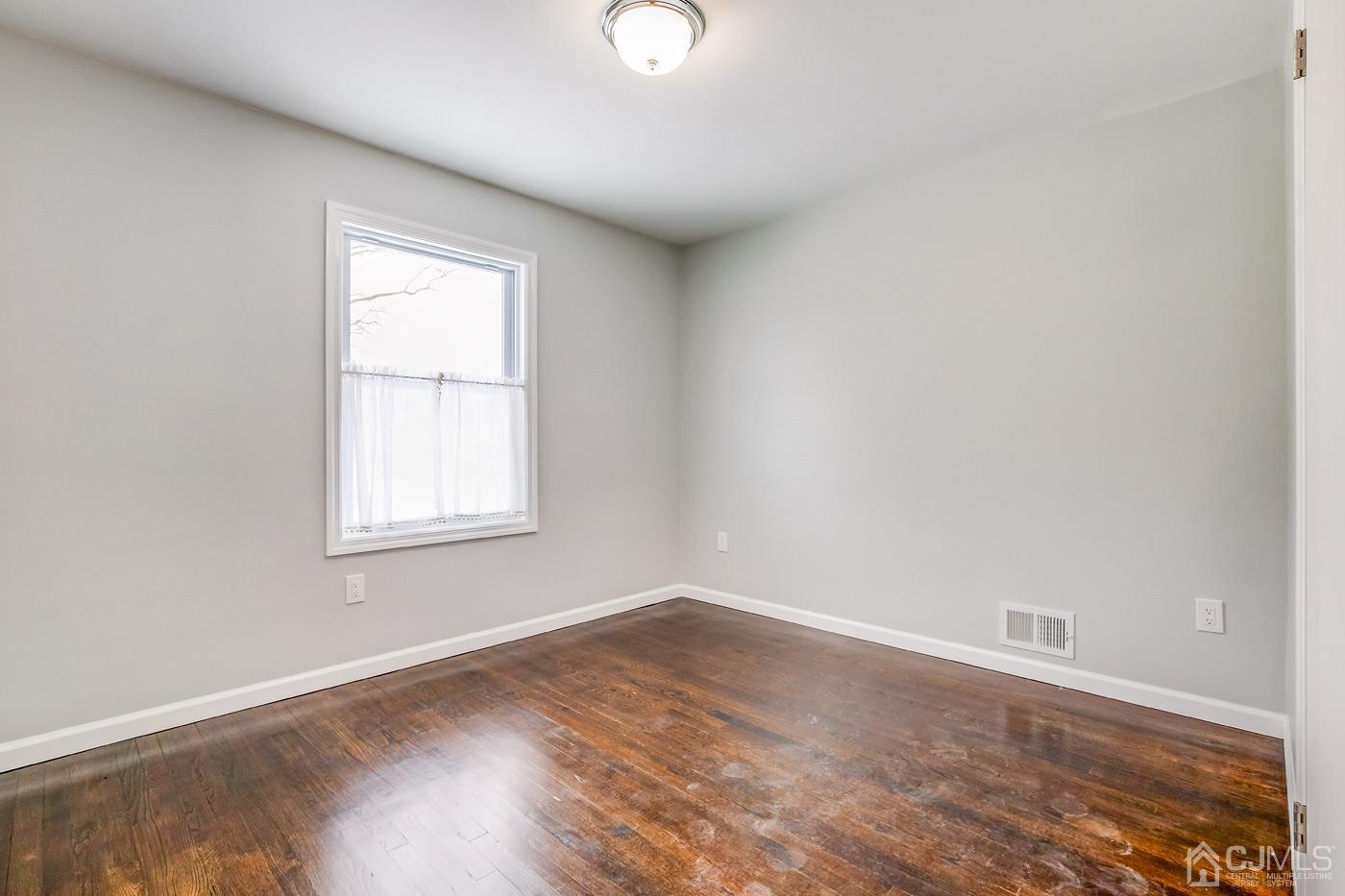 59 Stony Road Edison, NJ 08817 - Photo 21 of 27 an empty room with wooden floor and windows