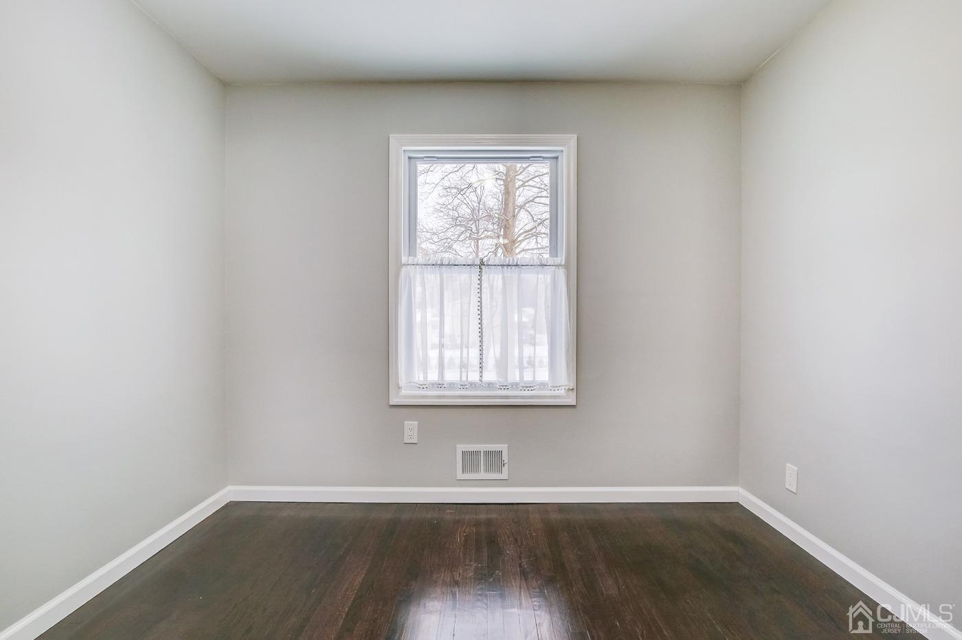 59 Stony Road Edison, NJ 08817 - Photo 22 of 27 an empty room with wooden floor and windows