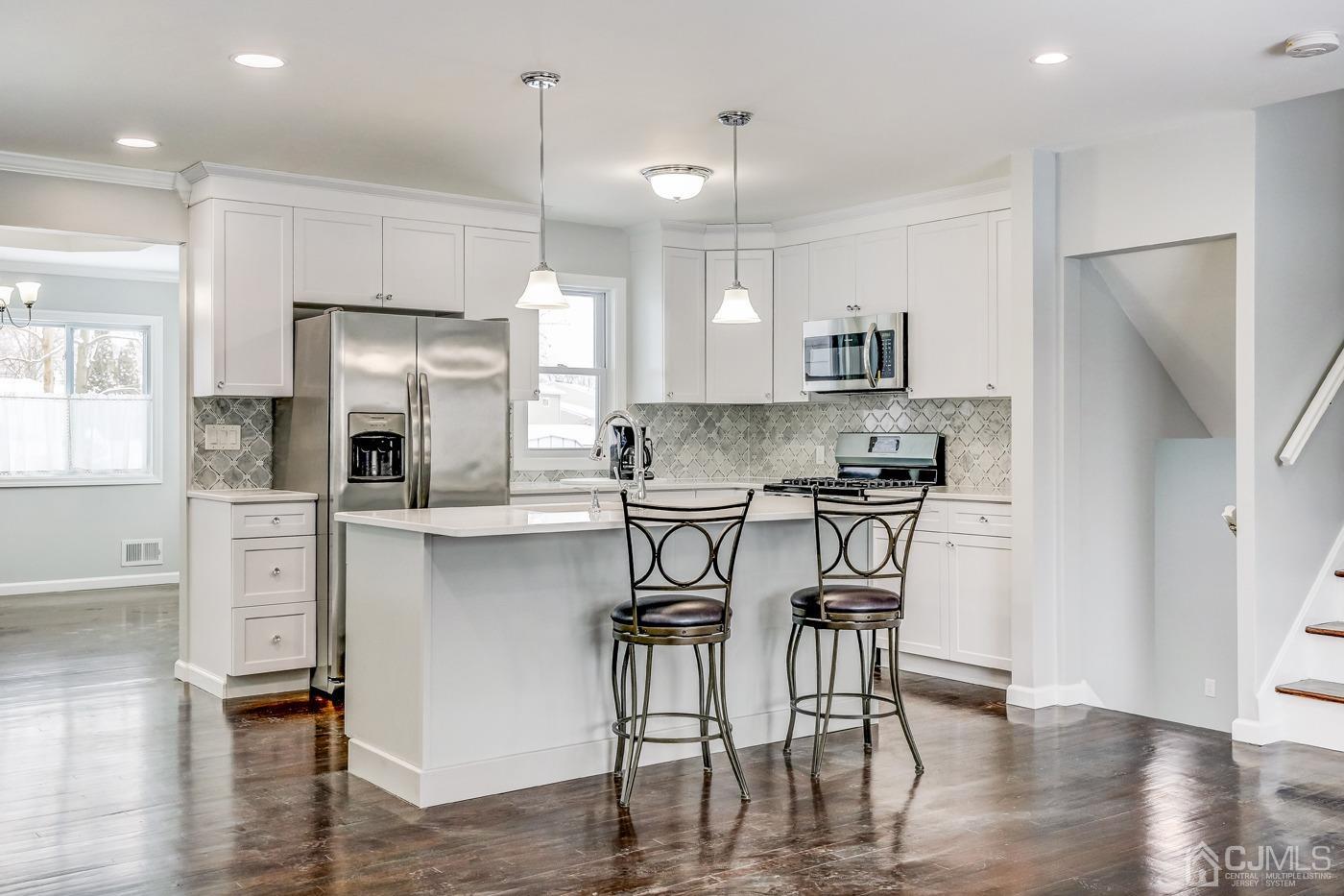 59 Stony Road Edison, NJ 08817 - Photo 6 of 27 a kitchen with stainless steel appliances granite countertop a refrigerator a stove a sink a dining table and chairs with wooden floor