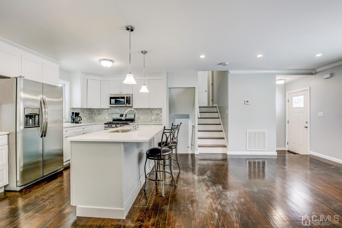 59 Stony Road Edison, NJ 08817 - Photo 7 of 27 a kitchen with kitchen island a sink stainless steel appliances and cabinets