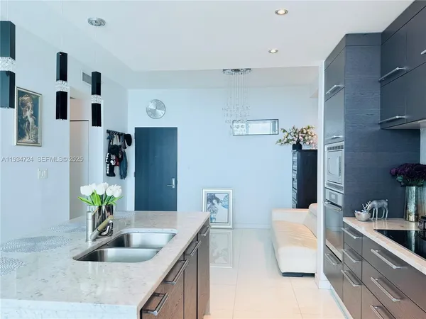 a kitchen with stainless steel appliances granite countertop a sink and white cabinets