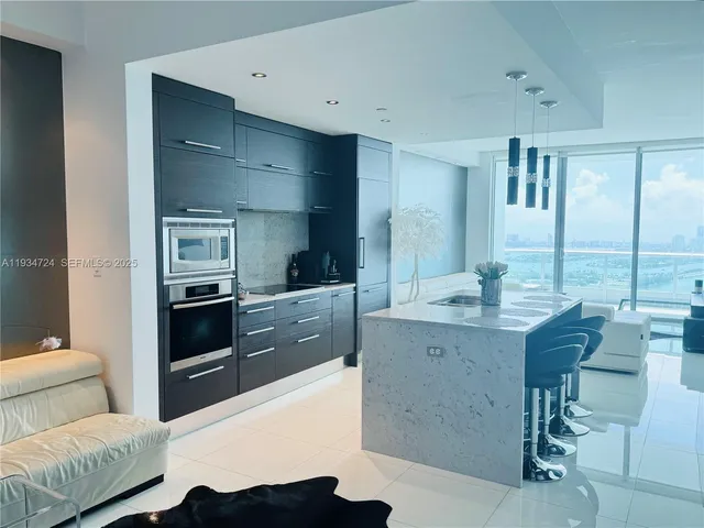 a kitchen with granite countertop a stove and white cabinets