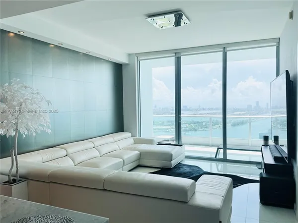a living room with furniture and a floor to ceiling window