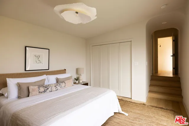 a bedroom with a bed and a painting on the wall